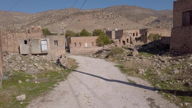 Dereici, also known as Killit, a Syriac village near Savur, Mardin, Turkey, dirt road between old stone houses and ruins at the foot of dry hills