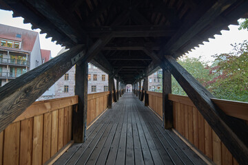 Fototapeta premium A scenic view through the interior of a historic wooden covered bridge in a European city setting
