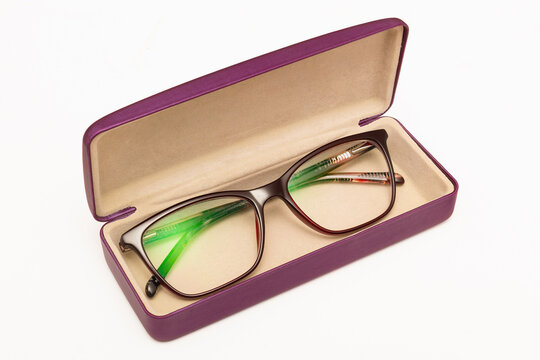A modern pair of women's eyeglasses inside an open hard shell case.