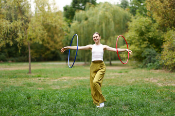 Athletic young woman exercising with hula hoops in park © New Africa
