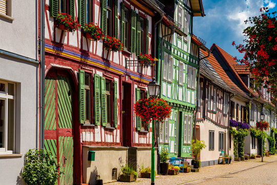 Colorful half-timbered houses with flowers and traditional shutters in the historic old town of Idstein, Hesse, Germany, on a sunny summer day.
