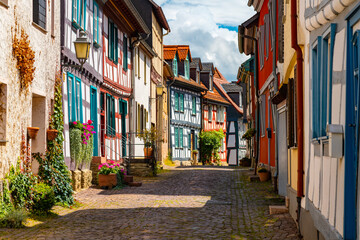 Obraz premium Historic Kreuzgasse in Idstein, Hesse, with colorful half-timbered houses, cobblestones and flowers in the picturesque old town on a sunny summer day.