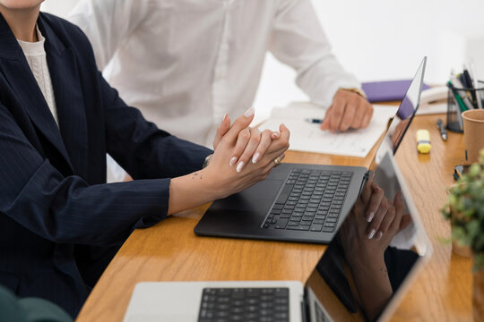 Business colleagues collaborating on laptop in office meeting
