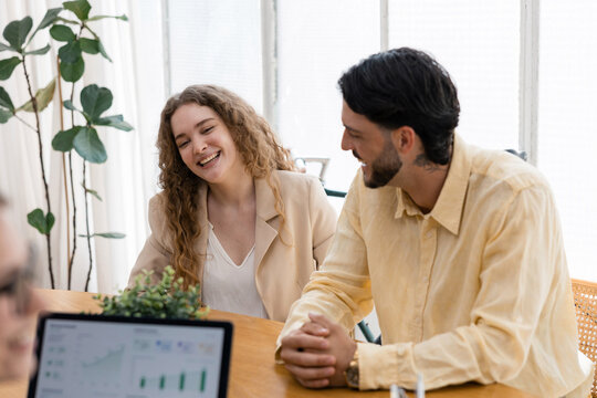 Young colleagues laughing during a business meeting
