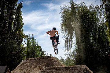 Obraz premium Dirt bike rider jumping on a dirt track in Arripiado village by the Tagus River, Portugal