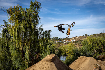 Obraz premium Dirt bike rider jumping on a dirt track in Arripiado village by the Tagus River, Portugal