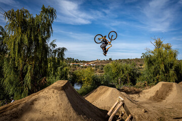 Obraz premium Dirt bike rider jumping on a dirt track in Arripiado village by the Tagus River, Portugal