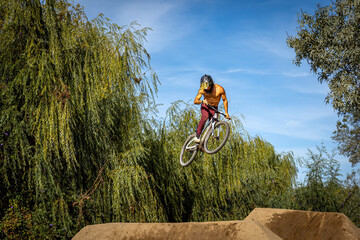 Obraz premium Dirt bike rider jumping on a dirt track in Arripiado village by the Tagus River, Portugal
