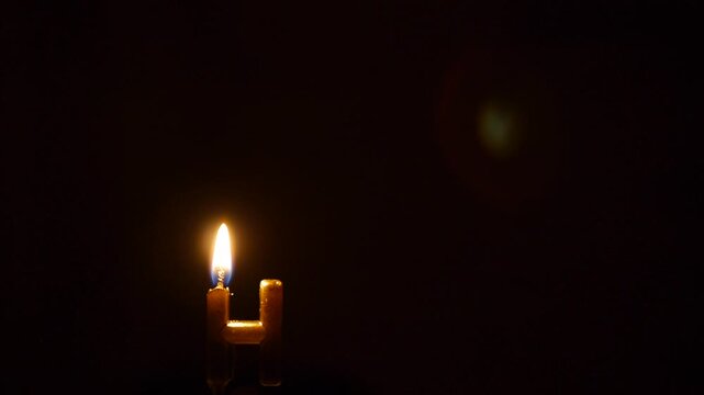 Glowing Golden Letter H Shaped Wax Candle Burning on Dark Background for Halloween Spooky Titles and Cinematic Monogram Intros