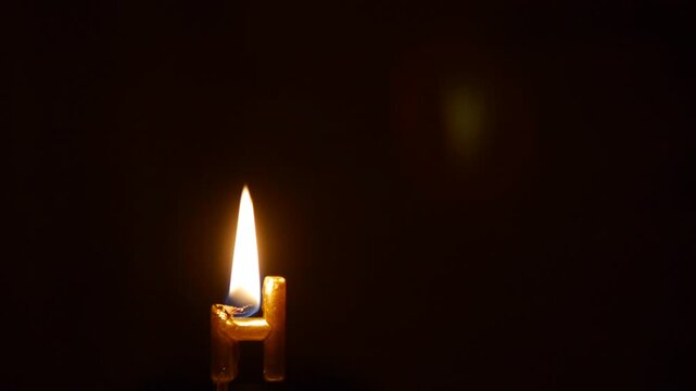 Burning Golden Letter H Candle Melting with Dripping Wax Isolated on Black Background for Birthday Video Typography and Alphabet Concepts