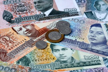 Cambodian riel money banknotes and coins on table. Cambodia cash bills of KHR currency © Viktor