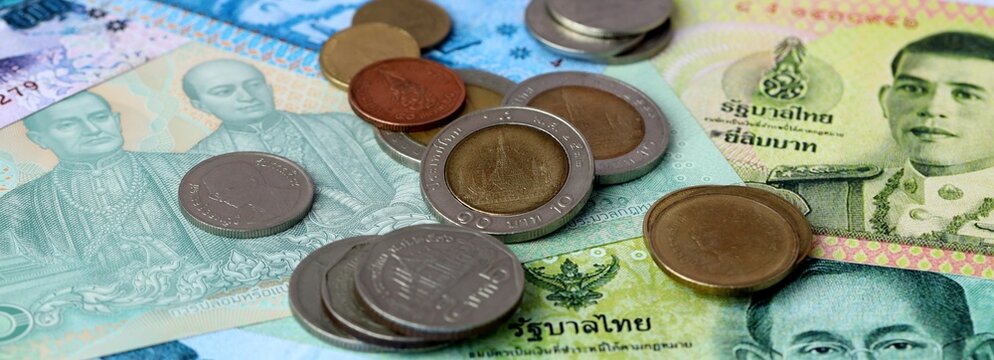 Thai baht money banknotes and coins on table. Thailand cash bills of THB currency