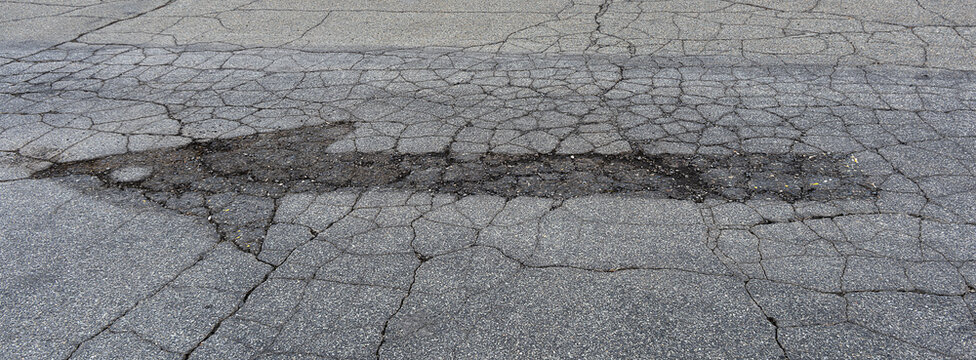 Imprint of arrow expunged from parking lot asphalt Xpan crop
