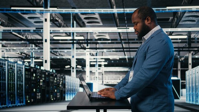 Technician using laptop for server hub maintenance tasks