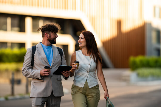 Business colleagues walking and discussing work outdoors