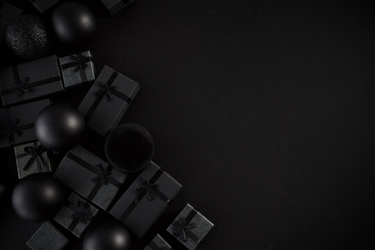 Black gift boxes and christmas ornaments creating holiday background