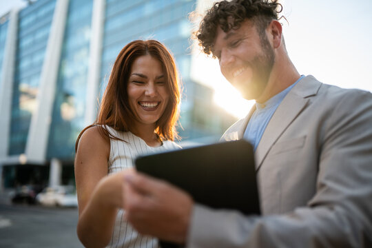 Business partners collaborating on tablet with city backdrop