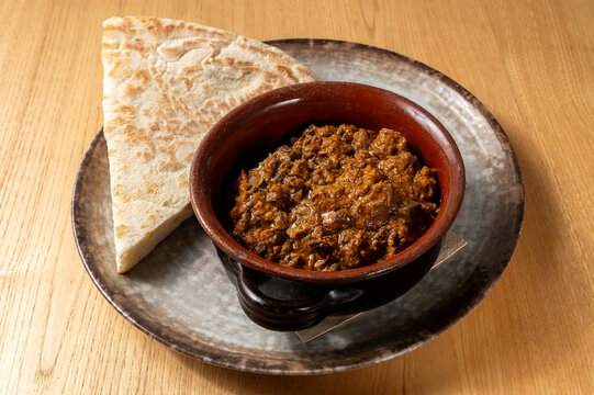 Traditional Umbrian lamb coratella stew served in a terracotta dish with torta al testo, a traditional regional flatbread.