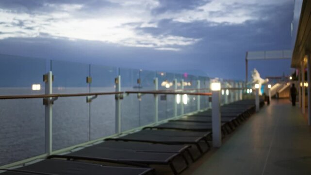 Cruise deck blurred bokeh background outdoor with glass railing and lounge chairs in soft focus; background backplate copyspace calm.