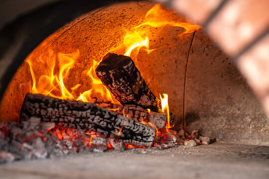 Roaring Fire and Burning Logs Inside Stone Pizza Oven