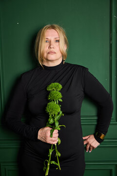 Thoughtful woman in subdued indoor setup with vibrant flora