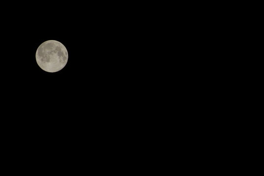 Bright full moon isolated against a dark night sky