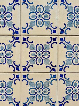 Blue and white azulejo tiles with hand-painted floral pattern on a wall in Portugal