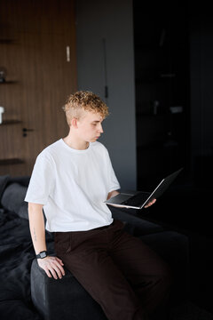 Young person immersed in digital device amidst trendy interior