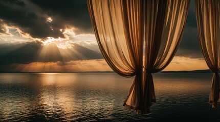 Fototapeta premium Elegant sheer curtains hang in front of window with ocean view. Sunlight breaks through dark clouds over calm sea at sunset. Beautiful fabric drapes frame scenic coast view. Peaceful evening