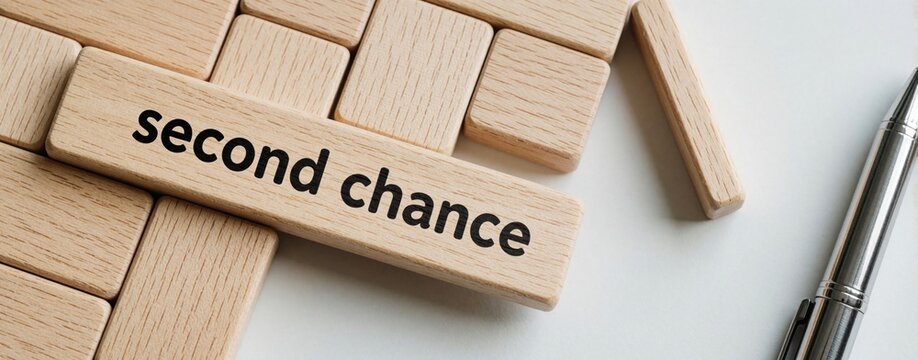 Wooden blocks with second chance text on white table. Metal pen lies near stacked timber pieces. Concept of business opportunity, career restart, new beginning, life change. Strategic decision