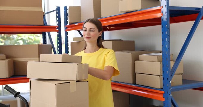 Worker checking boxes on shelves in warehouse