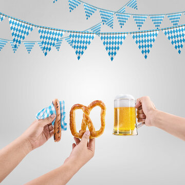 Oktoberfest celebration with traditional Bavarian food like sausage, pretzel, and beer mug, decorated with blue and white diamond bunting flags on gray background. Bavarian Oktoberfest Festival