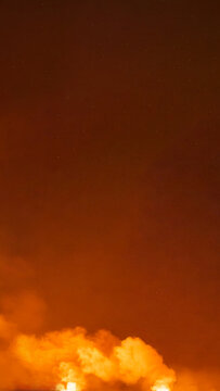 Dramatic fiery red and orange stormy sky with dark clouds and bright smoke, evoking apocalyptic or explosive atmosphere. Smoke background
