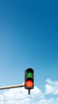 Traffic light showing both green and red signals simultaneously against a bright blue sky with light clouds, symbolizing contradiction or confusion. Quotes background