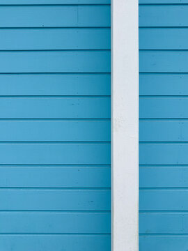 Blue Painted Wooden Siding with Vertical White Trim Column