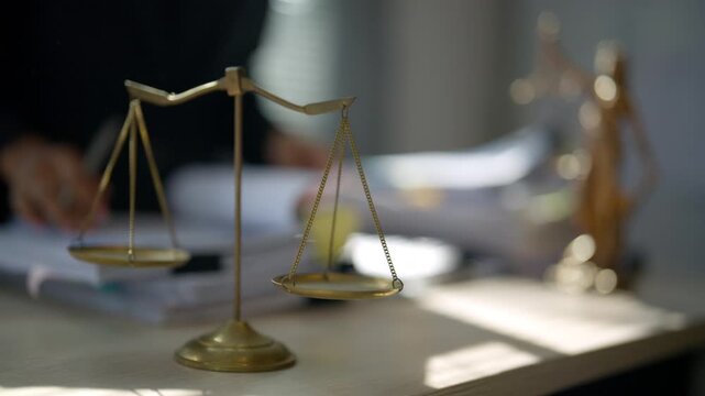 Scales of justice beside stacked legal files and documents on an office desk, representing law practice, case management, legal research, documentation, court procedures, and professional workload.