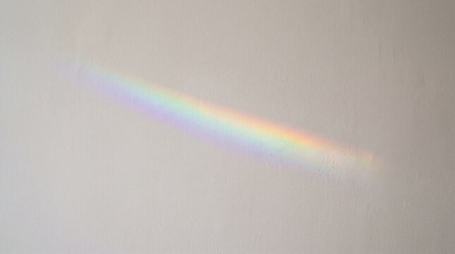 Soft rainbow light gently projected across a textured white wall, creating a subtle pastel spectrum with an airy minimalist atmosphere, ideal for wellness, creativity, beauty, lifestyle, positivity, a