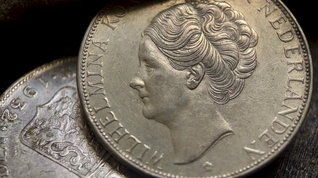 Macro video of a vintage Dutch gulden silver coin collection featuring an engraved female portrait, aged metallic surfaces, and authentic numismatic texture with visible circulation wear.