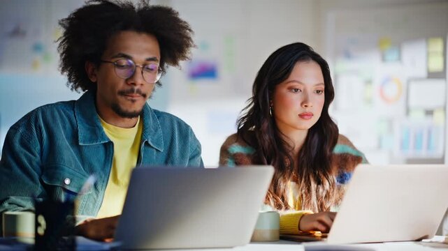 Young man and woman typing laptop computer office. Focused creative teamwork.