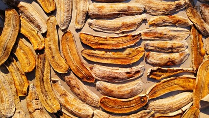 ​Traditional dried bananas food background, sun-dried banana slices pattern layout © Davit
