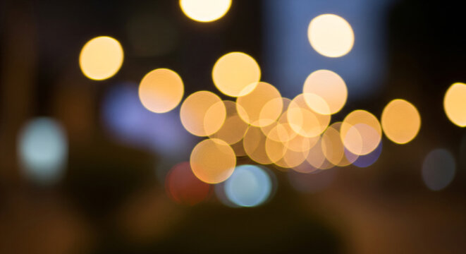 Festive night city street lights with soft glowing golden bokeh