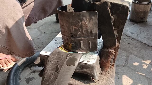 Mechanic repairing inner tube using traditional heat vulcanization press clamp method on tire repair shop