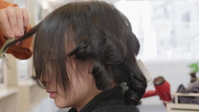 Hairdresser combing curls after a perm treatment
