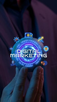 Businessman hand vertical shot holding glowing digital marketing text hub with promotion icons. Corporate online advertising campaign management, audience outreach, and brand strategy idea concept.