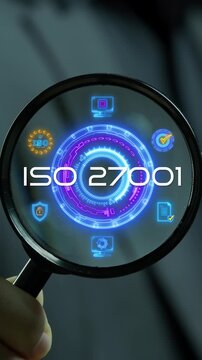 Businessman holding magnifying glass vertical shot inspecting glowing ISO 27001 standard hub. Information security management system certification, cyber data privacy audit, and compliance concept.