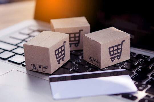 Shopping online. Credit card and cardboard box with a shopping cart logo on laptop keyboard. Shopping service on The online web. offers home delivery