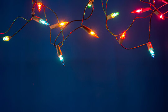 Christmas lights string on blue background with copy space