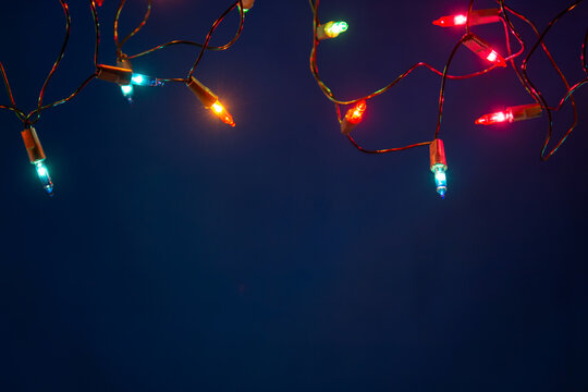 Christmas lights string on blue background with copy space
