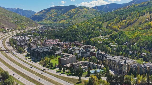 Vail, colorado, a mountain town and ski resort, sits in a valley surrounded by autumn foliage drone video 4K