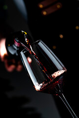 Obraz premium Premium Pinot Noir red wine with sommelier — decanting process in dark cellar. Exclusive food pairing preparation for luxury dinner. High quality alcoholic beverage featuring deep ruby color.